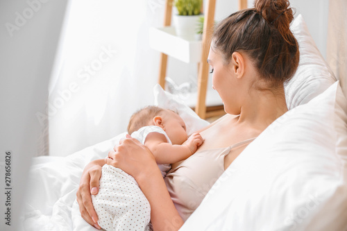 Tableau sur toile Young woman breastfeeding her baby at home