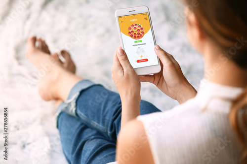 Foto Woman with mobile phone ordering food online