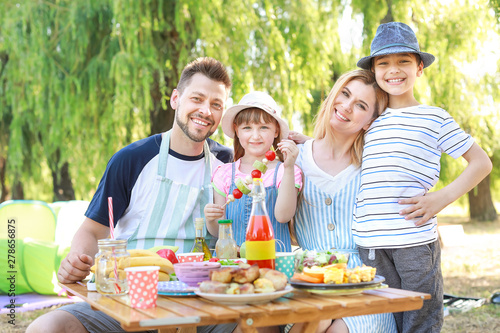 Happy family having picnic on summer day