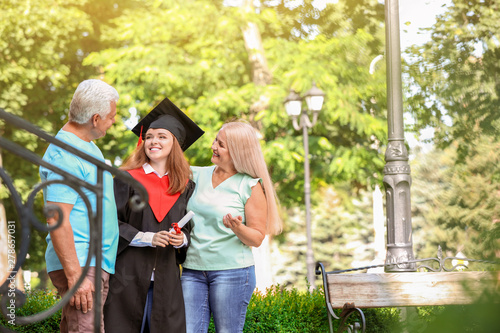 Happy young woman with her parents on graduation day photo