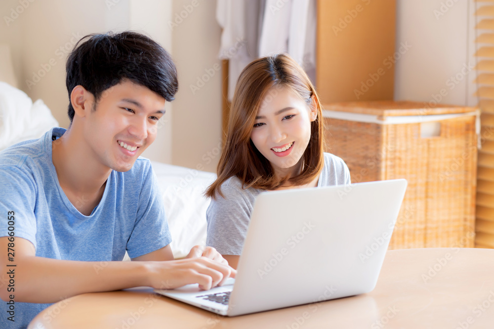 Asian young couple using laptop computer think and searching internet together, man and woman casual smiling work at home with happy and relax, communication and business concept. Asian young couple using laptop computer think and searching internet together, man and woman casual smiling work at home with happy and relax, communication and business concept.