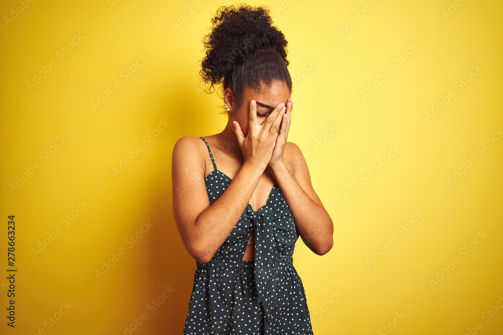 African american woman wearing summer casual green dress over isolated yellow background with sad expression covering face with hands while crying. Depression concept. African american woman wearing summer casual green dress over isolated yellow background with sad expression covering face with hands while crying. Depression concept.