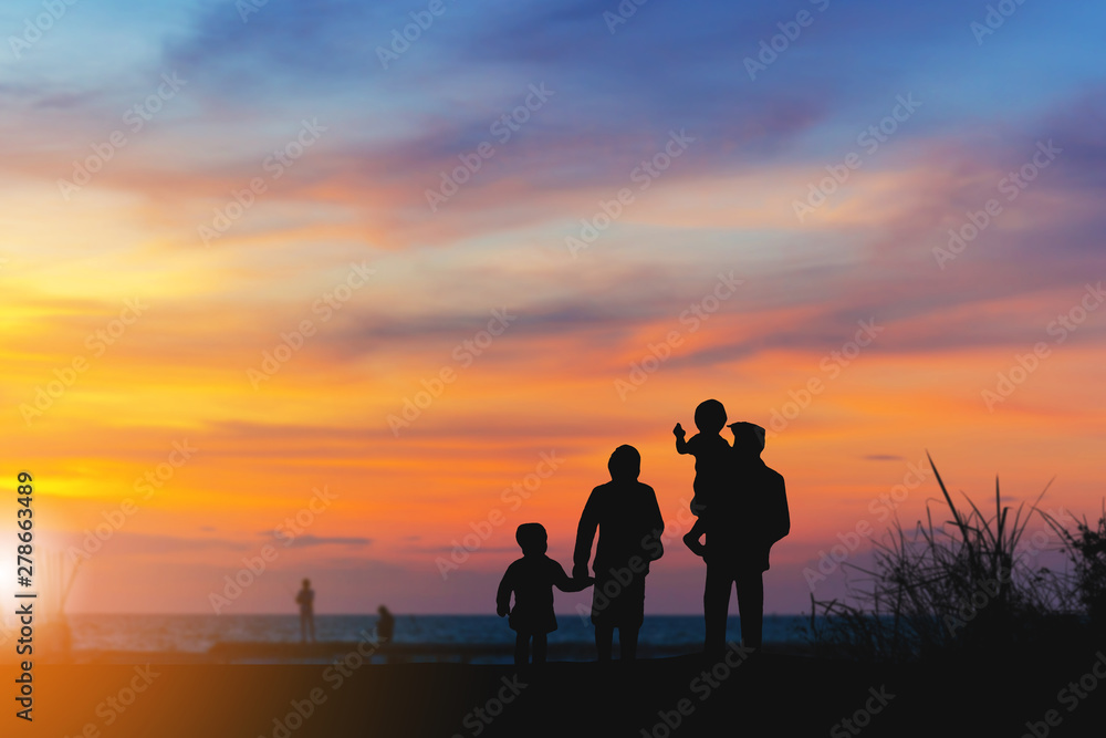 Silhouette of Grandfather grandmother granddaughter and grandchild looking sun down and walking on the beach evening sunset background, Happy family concept