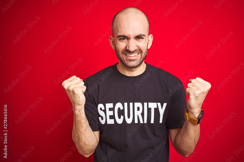 Young safeguard man wearing security uniform over red isolated background celebrating surprised and amazed for success with arms raised and open eyes. Winner concept. Young safeguard man wearing security uniform over red isolated background celebrating surprised and amazed for success with arms raised and open eyes. Winner concept.