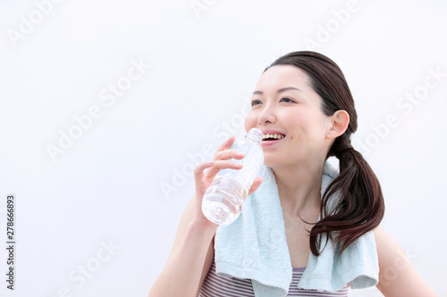 ペットボトルの水を飲む女性