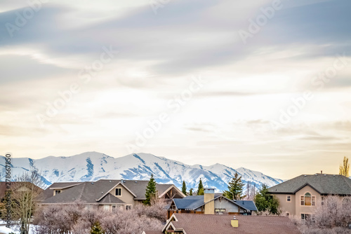 Neighborhood in winter with snow covered mountain and overcast sky background photo