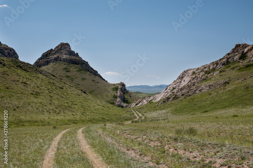 Kazakhstan, foothills. Spacious steppes surrounded by low mountains. Beautiful view of horizon.