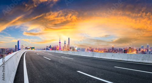 Empty asphalt highway and modern city skyline in Shanghai at sunset,China