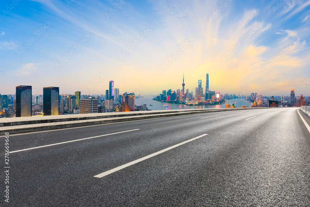Empty asphalt highway and modern city skyline in Shanghai at sunset,China Empty asphalt highway and modern city skyline in Shanghai at sunset,China