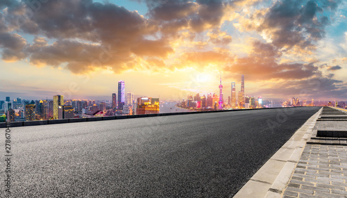 Empty asphalt highway and modern city skyline in Shanghai at sunset China