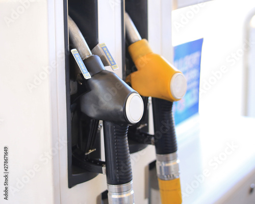 Close up gasoline station, gas pump nozzle, petrol station. Multi-colored handles two filling guns