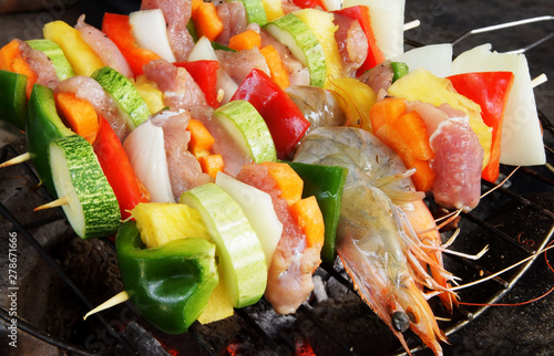 BBQ grill food, grilled meat, shrimps and vegetables.