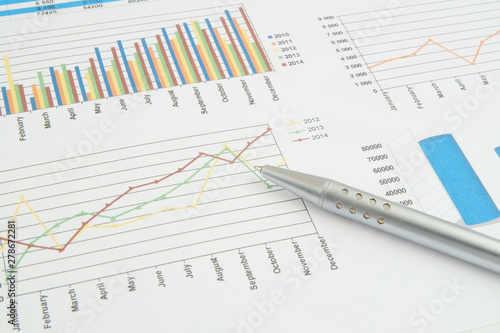 Business concept, silver pen on financial charts and graphs