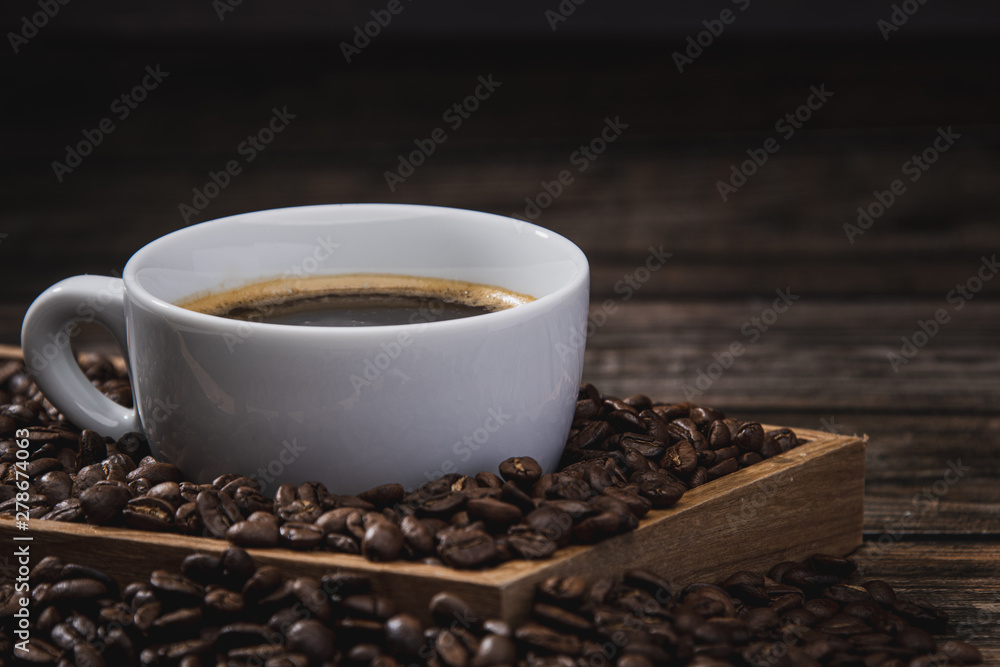 Close up cup of coffee with beans on wooden table Close up cup of coffee with beans on wooden table