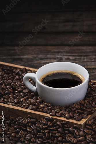 cup of coffee with beans on wooden table © Sitthikorn