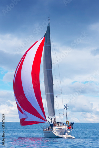 holiday sailboat with red and white spinnaker sail, Adriatic sea, Croatia