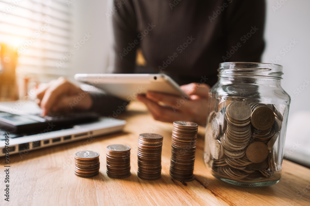 businessman holding coins putting in glass with using smartphone and calculator to calculate concept saving money for finance accounting businessman holding coins putting in glass with using smartphone and calculator to calculate concept saving money for finance accounting