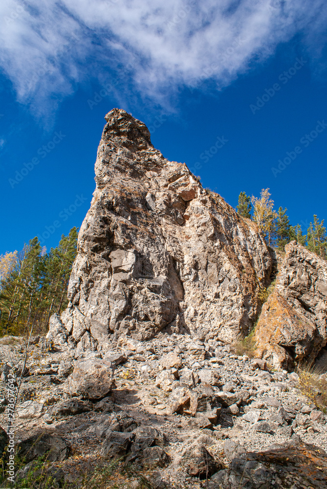 Steep cliff against the blue sky. Close-up on a sunny autumn day