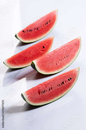 Slices of fresh watermelon on white marble background