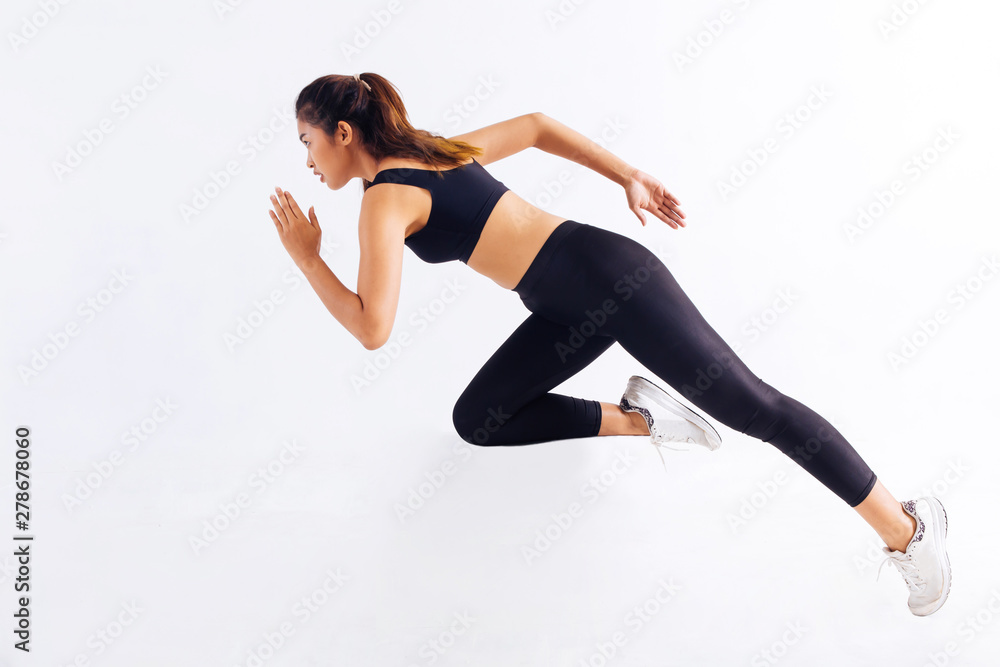 Side view of slim Asian female in black sportswear sprinting fast during workout against white background