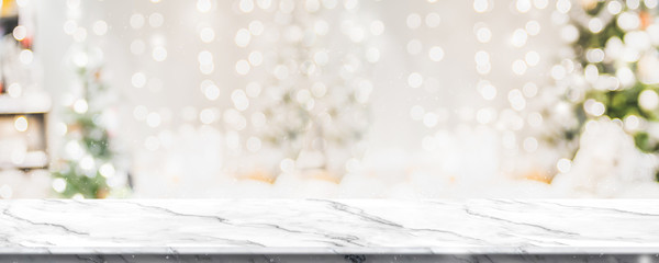 Christmas background of marble table top with abstract warm living room decor with christmas tree string light blur bokeh with snow,Holiday backdrop, panoramic Mock up banner for display of product.