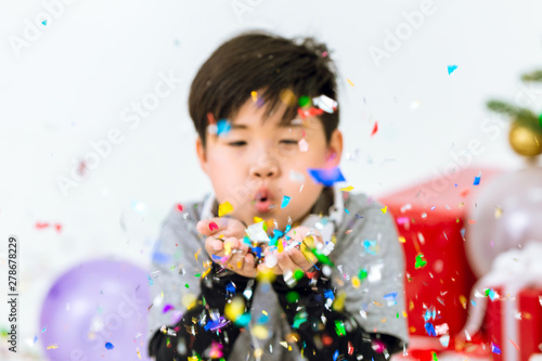 boy blowing glitter in the party. childrens fun happiness moment concept.