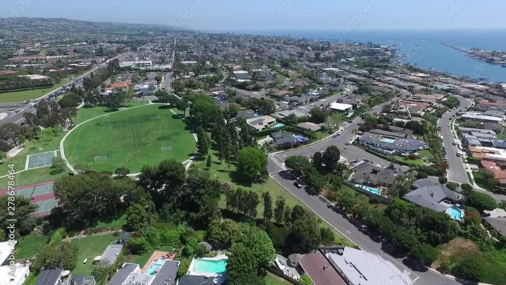 Aerial drone slowly flying over homes and Irvine Terrace park in