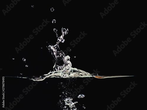 Water splash, rippling surface, water bubbles in air and underwater, isolated on black background, close up view. Abstract black background for overlays design, screen blending mode layer