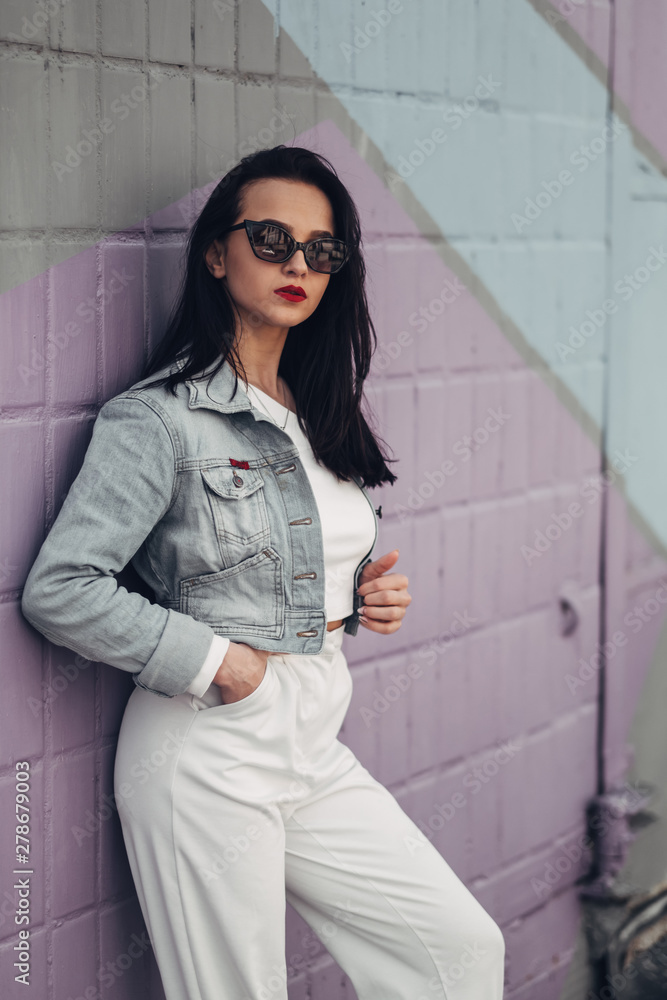 Beautiful Brunette Girl in Sunglasses White Pants and Jeans Jacket, Red Lipstick Beautiful Brunette Girl in Sunglasses White Pants and Jeans Jacket, Red Lipstick