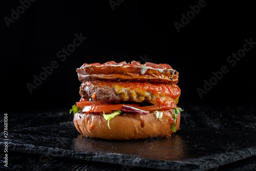 Crispy burger with sausages, tomatoes sauce, flowing mozzarella, pork meat steak.