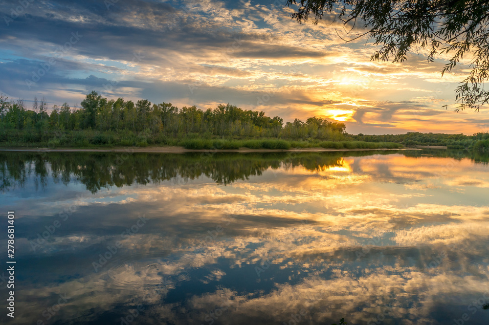 Beautiful sunset nature landscape with calm river and picturesque clouds
