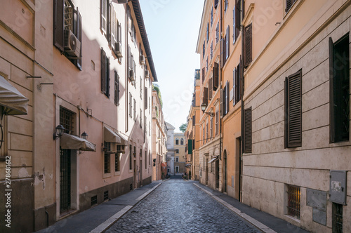 Narrow European street with stone road and old buildings © Olga K