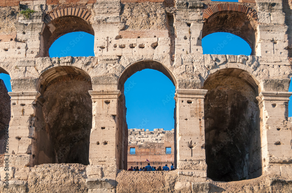 Close up of Colosseum wall with arch windows and blue sky Close up of Colosseum wall with arch windows and blue sky
