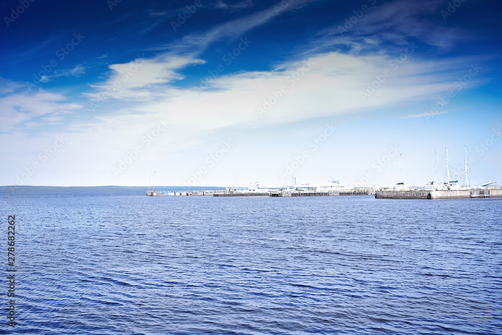 Beautiful clouds over Lake Onega. Colorful view of the ships at the pier. Beautiful clouds over Lake Onega. Colorful view of the ships at the pier.