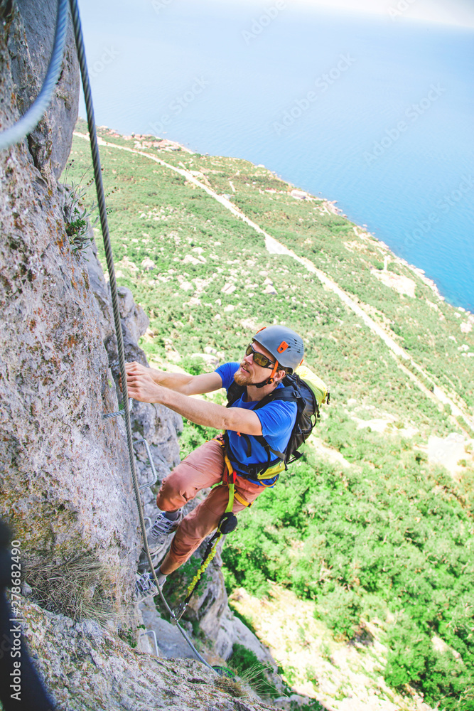 Obraz premium Man climbing mountain. 