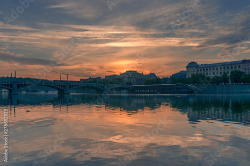 Prague cityscape with epic sky reflected in Vltava river at sunrise