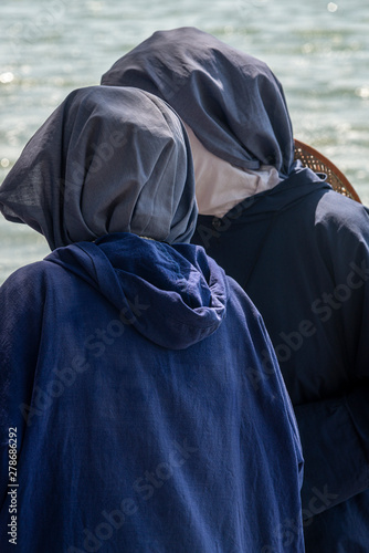 Tabgha, Israel - May 18 2019 : Nuns visiting the shore of Sea of Galilee in Tabgha church