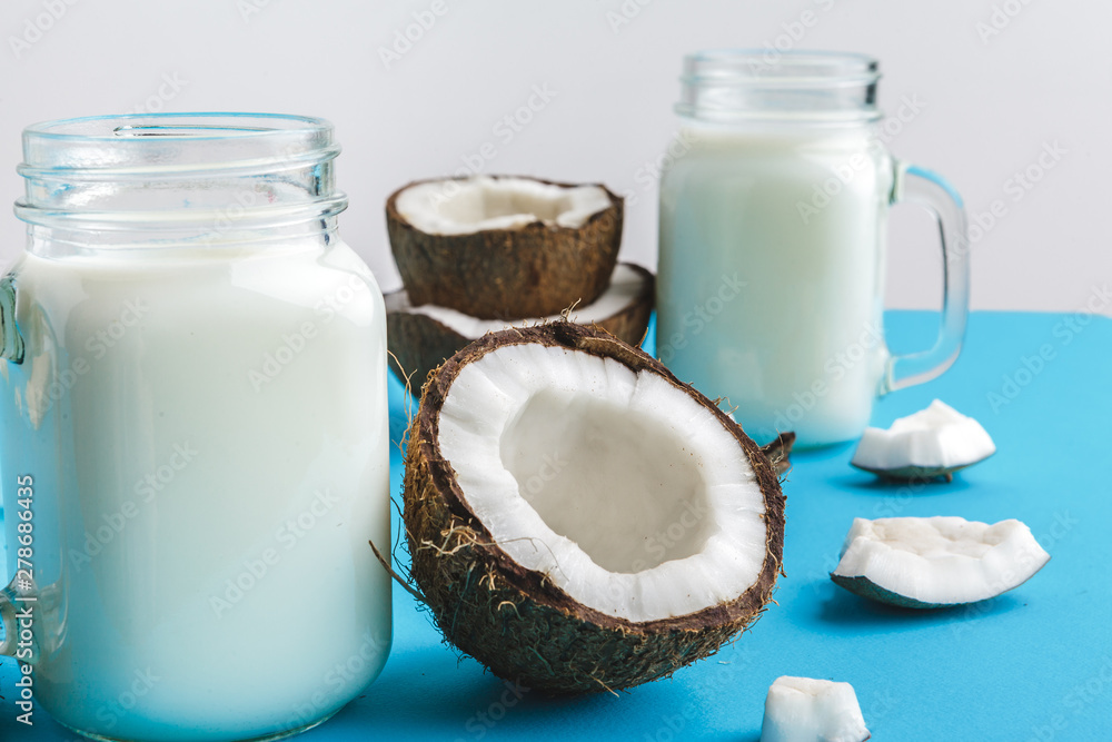 Coconut and a glass of coconut milk on a table. Healthy food concept Coconut and a glass of coconut milk on a table. Healthy food concept
