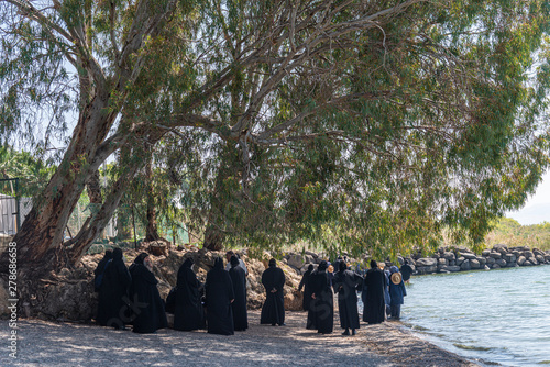 Tabgha, Israel - May 18 2019 : Coptic monks visiting the shore of Sea of Galilee in Tabgha church © studiodr