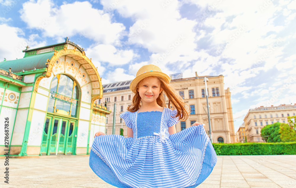 Φωτογραφία Little cute girl in blue dress  playing on the street of Vienna, Austria
