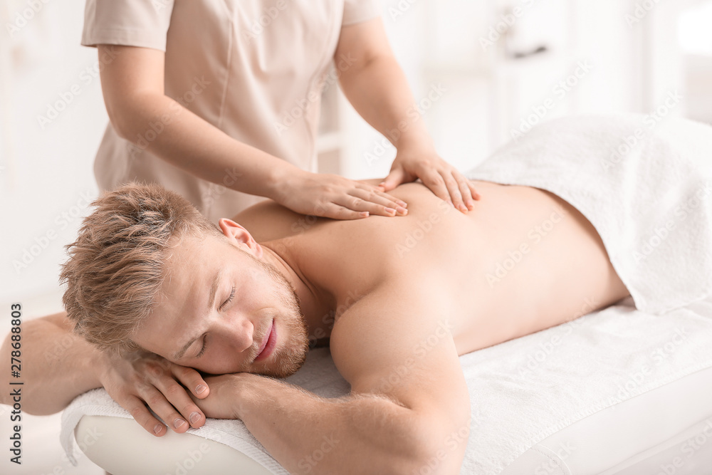 Handsome young man receiving massage in spa salon Handsome young man receiving massage in spa salon