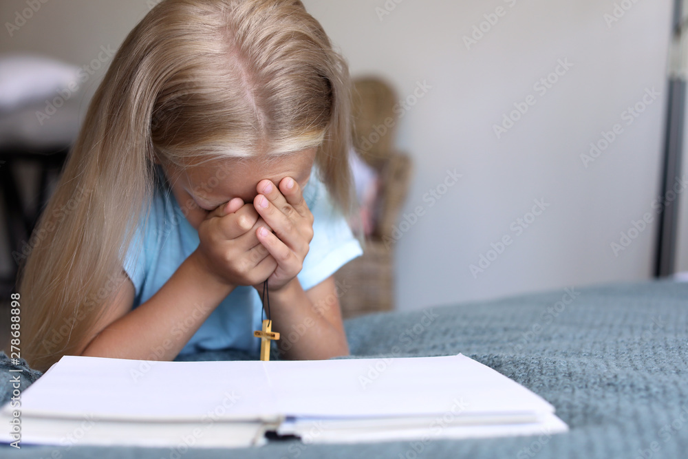 Little girl praying at home