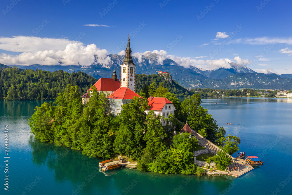 Bled, Slovenia - Aerial drone view of Lake Bled (Blejsko Jezero) with the Pilgrimage Church of the Assumption of Maria on an island and Bled Castle and Julian Alps at backgroud on a bright summer day