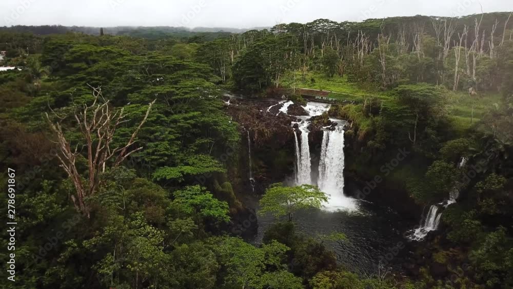 Rising Up, Panning Down drone shot heading towards a gushing PeePee Falls after a rainstorm on the Big Island of Hawaii. Rising Up, Panning Down drone shot heading towards a gushing PeePee Falls after a rainstorm on the Big Island of Hawaii.