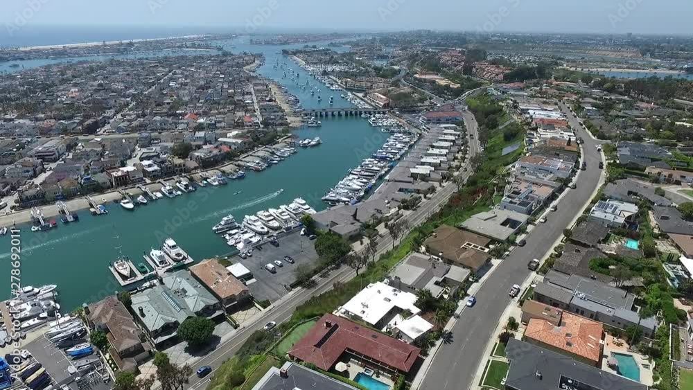 Aerial drone slowly flying over homes in Newport Harbor facing north channel of Balboa Island, Newport Beach, Orange County, California Aerial drone slowly flying over homes in Newport Harbor facing north channel of Balboa Island, Newport Beach, Orange County, California