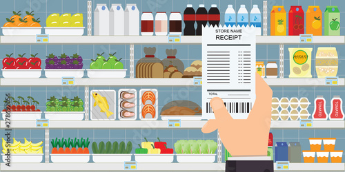 Human hand holding grocery shopping receipt.