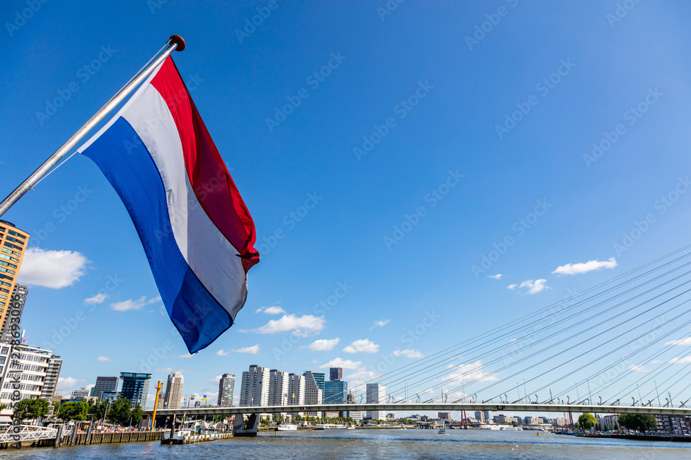 Fototapeta premium Dutch national flag waving on a boat in Rotterdam