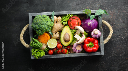 Fresh vegetables in a wooden box. Vegetarian food. Top view. Free space for your text.
