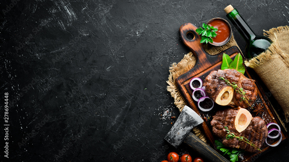 Osso buco cooked Veal shank on a black background. Top view. Free space for your text. Osso buco cooked Veal shank on a black background. Top view. Free space for your text.