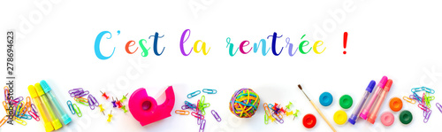 Foto Panorama of colorful school supplies  on white background with with text c'est